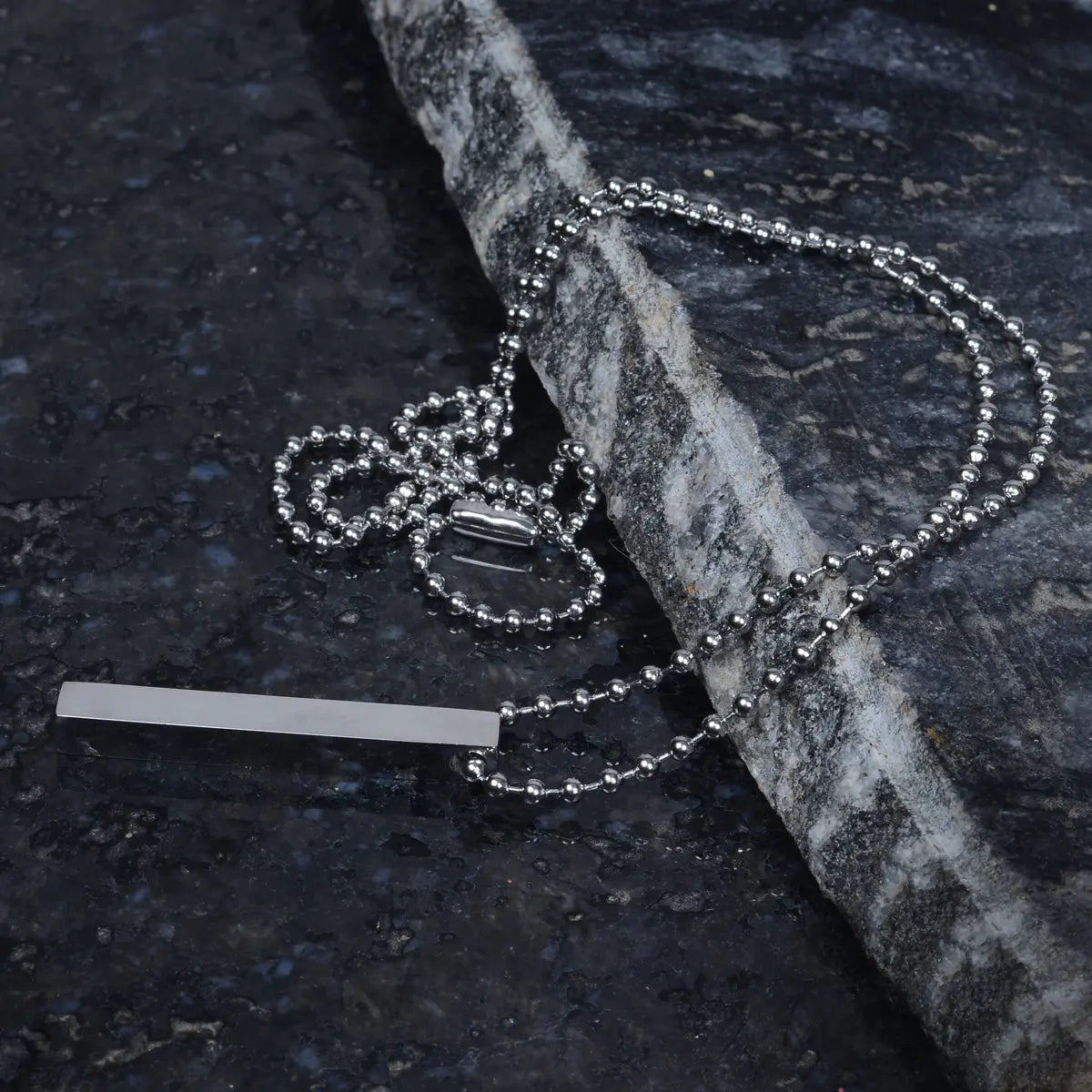 Silver chain for men on a dark stone surface by Supreme Stud