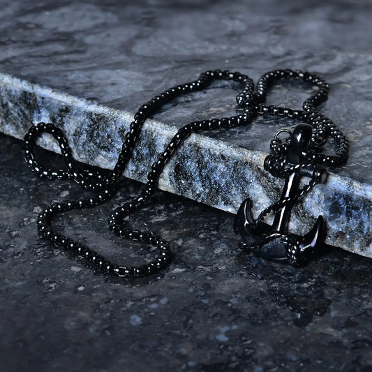Black anchor pendant for men on a stone surface by Supreme Stud