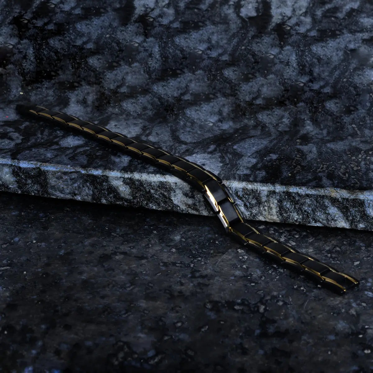 Gold Black bracelet on a textured dark surface by Supreme Stud