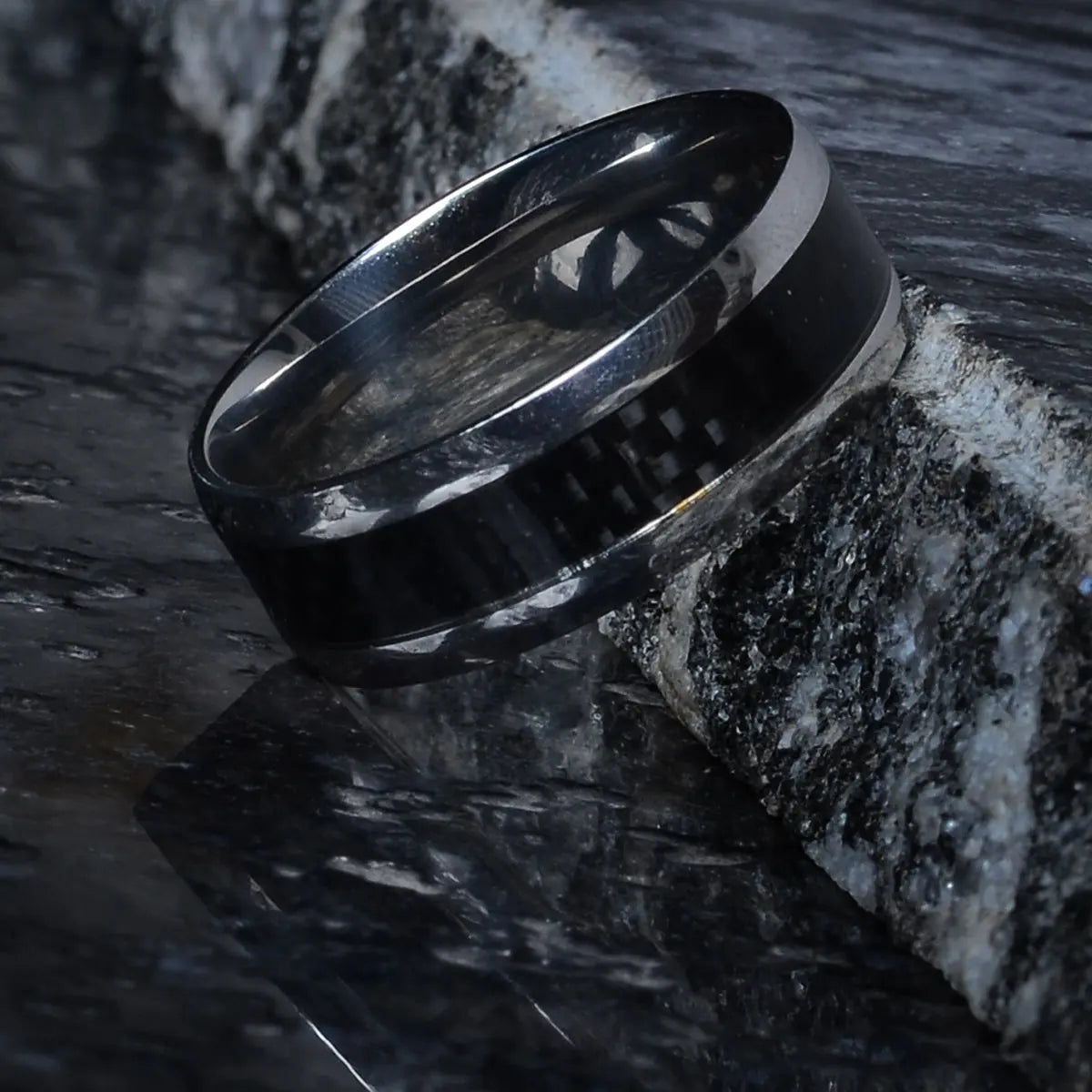 Stainless steel ring for him on a textured stone surface by Supreme Stud
