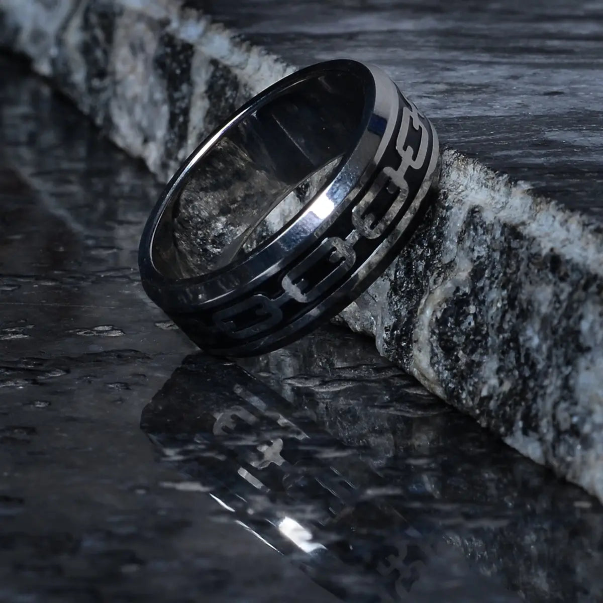 Steel ring for men with black engraving on a dark stone surface by Supreme Stud
