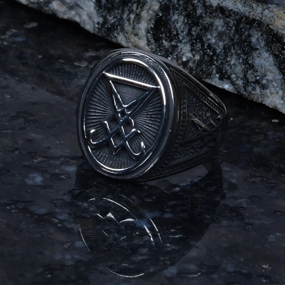 Lucifer stainless steel ring for men with a symbol on a dark stone surface by Supreme Stud