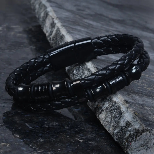Black braided leather bracelet for men on a stone surface by Supreme Stud