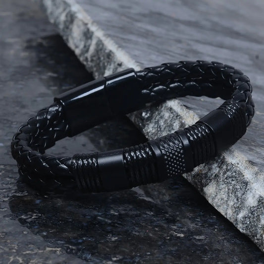 Black braided leather bracelet for men on a stone surface by Supreme Stud